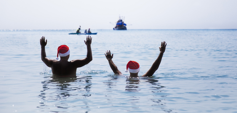 two colleagues swimming after jumping off boat at work party