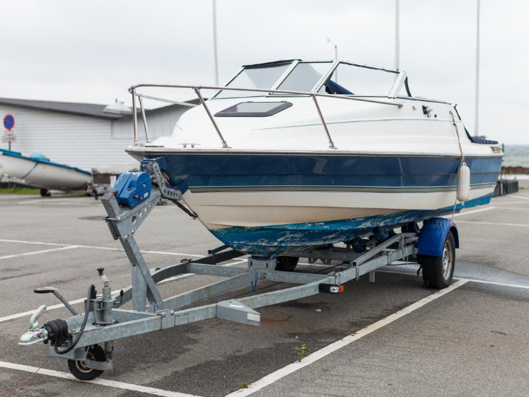 A boat on a boat trailer in a yard