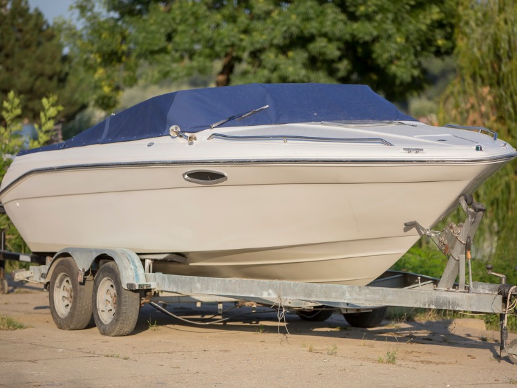 A boat on a trailer in a yard