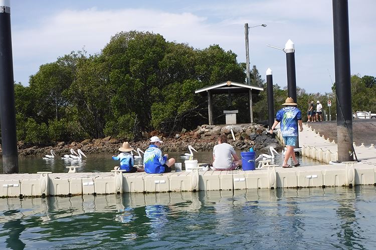 Family cleaning catches on a boat ramp